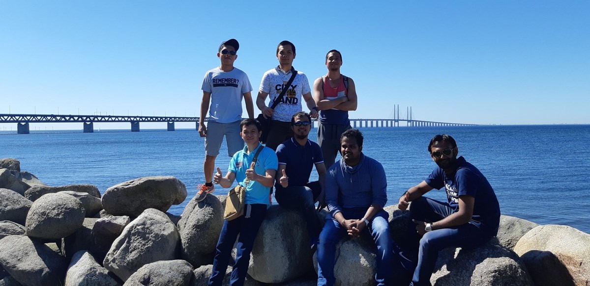 Seven seafarers standing in fornt of the Öresund bridge.