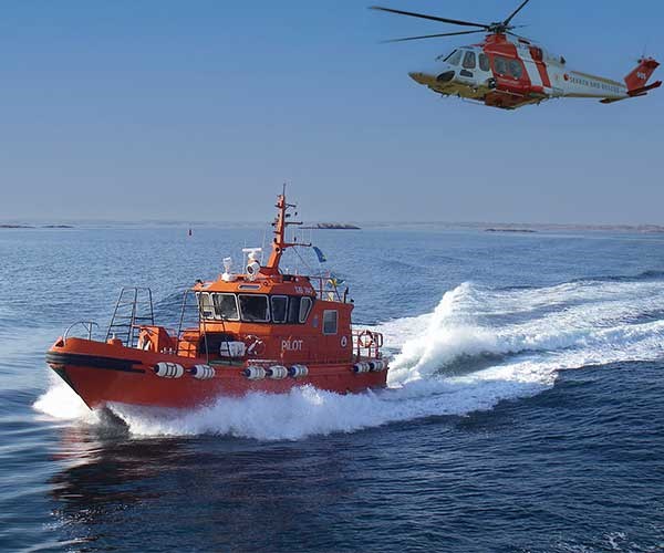 Bild på lotsbåt och helikopter en fin och klar dag