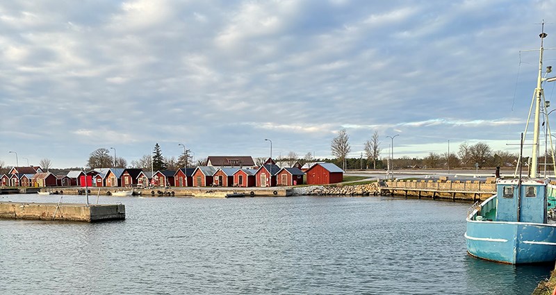 Foto på Kappelshamn hamn med stugor i förgrunden.