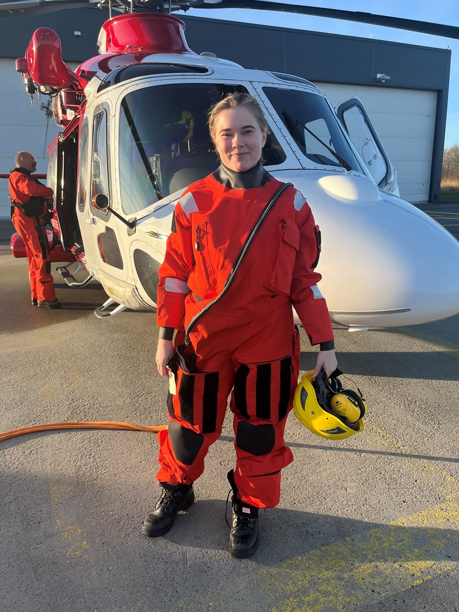 Praktikant Elvira ståendes framför en av Sjöfartsverkets helikoptrar.