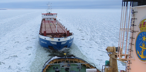 Ett handelsfartyg assisteras av isbrytaren Atle.