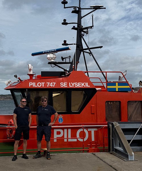 Bild på två lotsar framför en lotsbåt