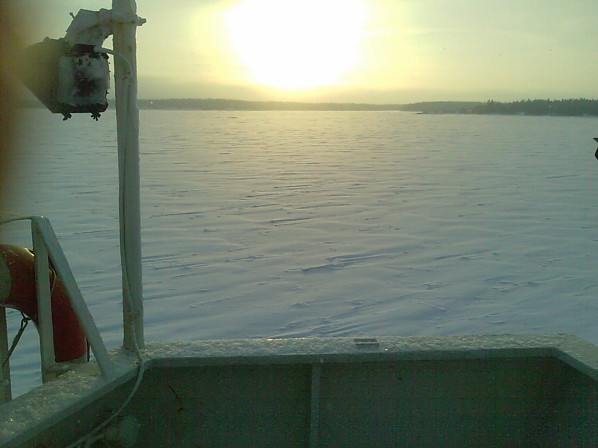 Solnedgång i vinterlandskap över sjö