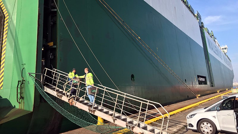 Field representative delivers books on the gangway.