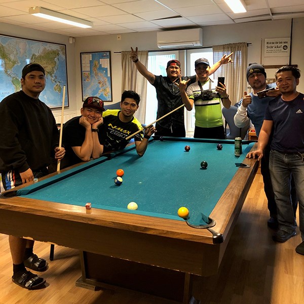 Many guests surrounding the pool table