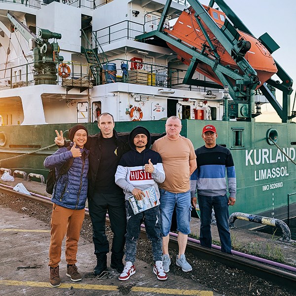 A group of seafarers standing in front of their ship