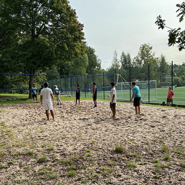 Ett gäng sjöfolk spelar beachvolleyboll