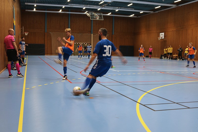 Fotbollsspelare på väg att skjuta boll mot en man som är redo att blockera skottet