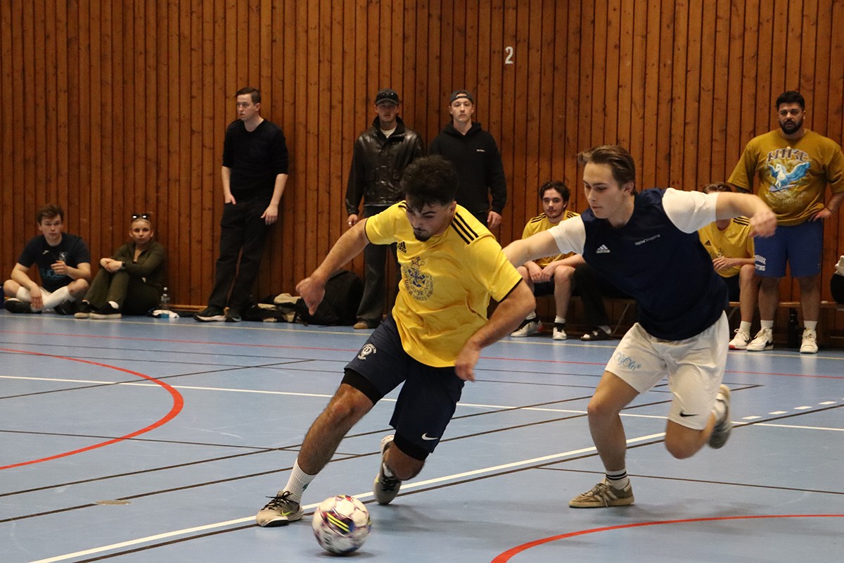 Två inomhusfotbollsspelare i en duell