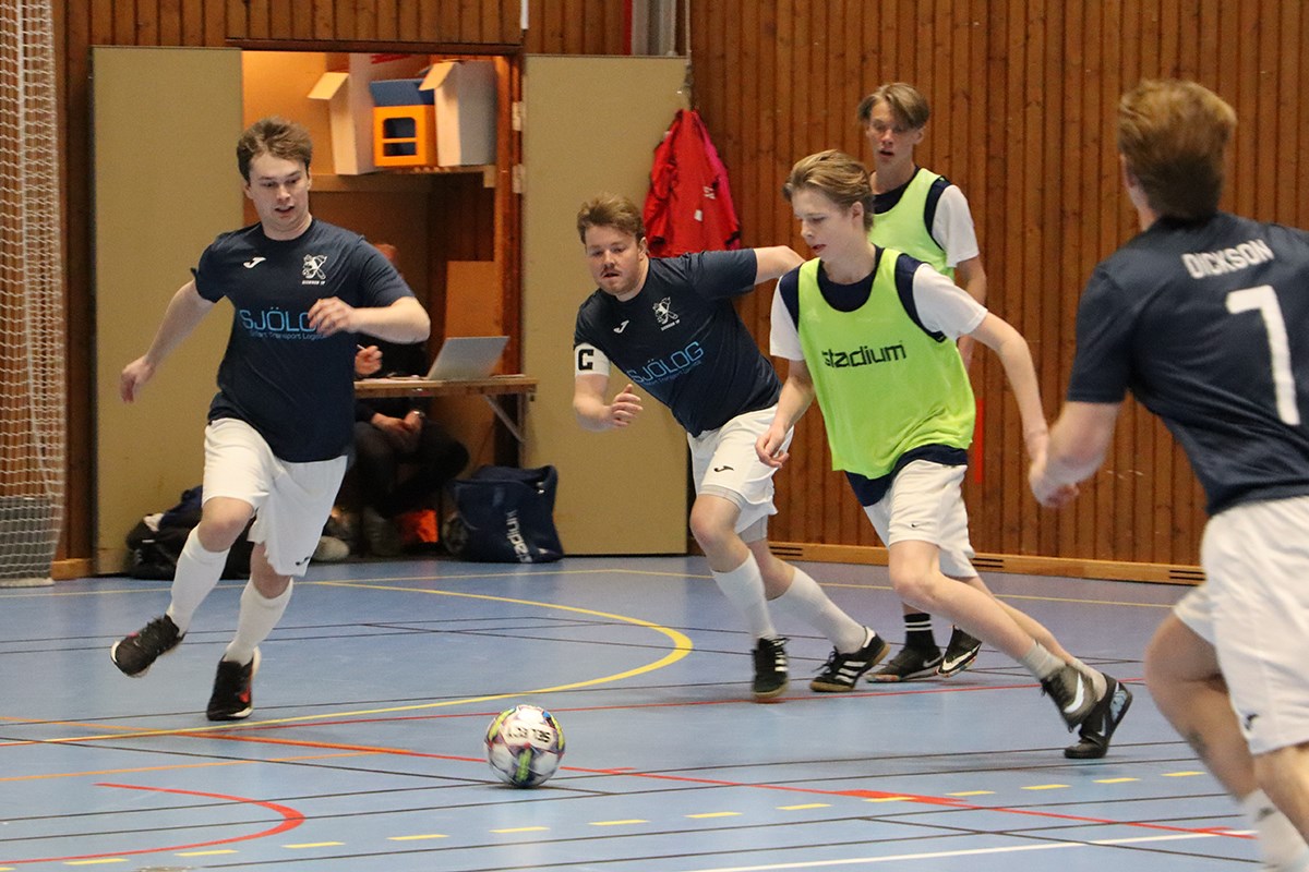 Flera inomhusfotbollsspelare jagar bollen